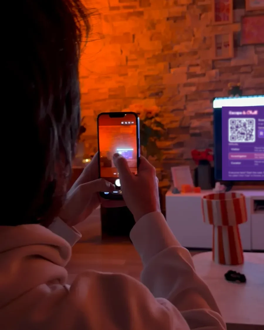 A player scans with their phone the QR code shown on the TV